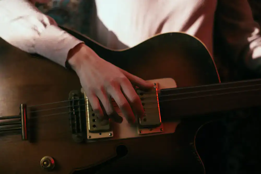 A beautifully crafted acoustic guitar resting on an aged brass stand