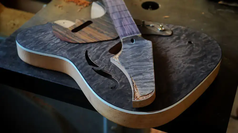 Vintage guitar resting elegantly on a luthier's workbench