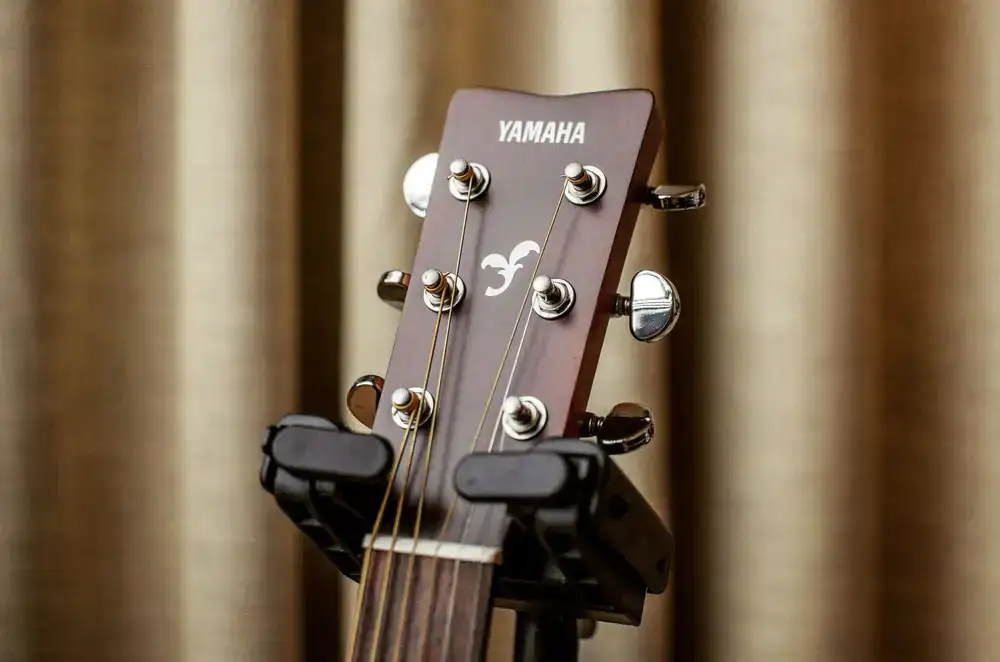 Side by side comparison of a brand new guitar and a worn vintage headstock