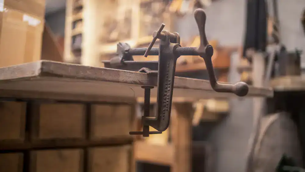Wooden clamps securing a delicate guitar body restoration